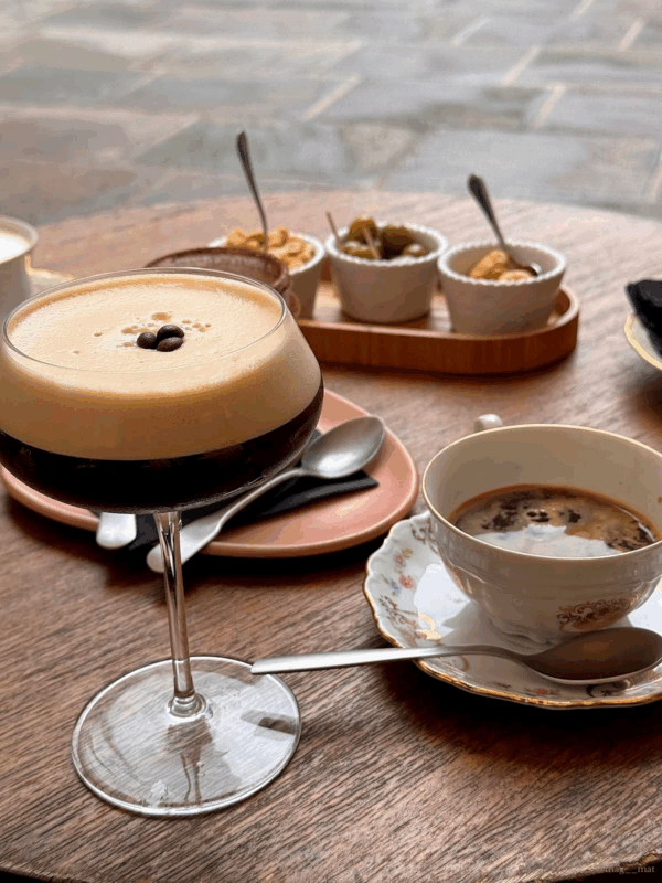 Espresso martini with coffee and finger food on a café table in front of the cathedral in Como, Italy. UGC solutions for small hotels